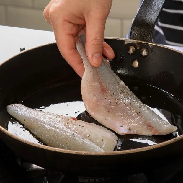 Thả cá nhẹ nhàng vào chảo dầu nóng